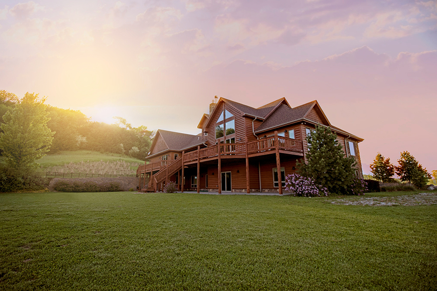Rustic log cabin surrounded by trees, showcasing a cozy home in Marquette, MI – ideal for buyers looking for Upper Peninsula real estate